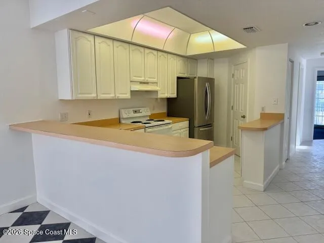 a kitchen with stainless steel appliances a refrigerator sink and cabinets