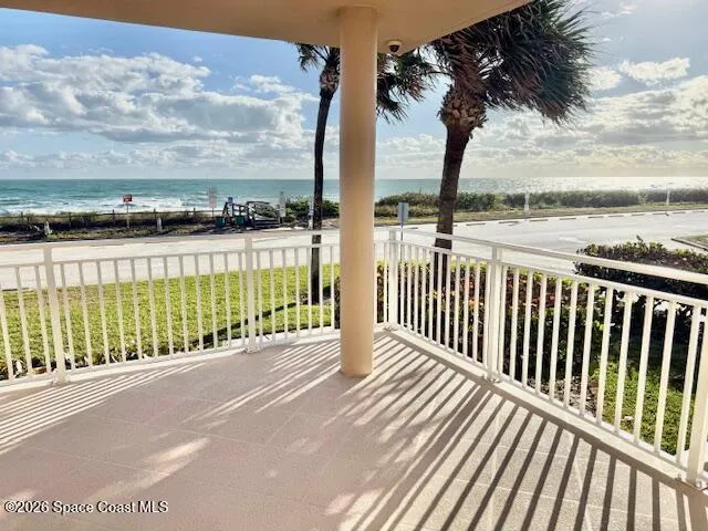 a view of a balcony with floor to ceiling windows yard and ocean view