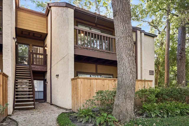 a front view of a house with a tree