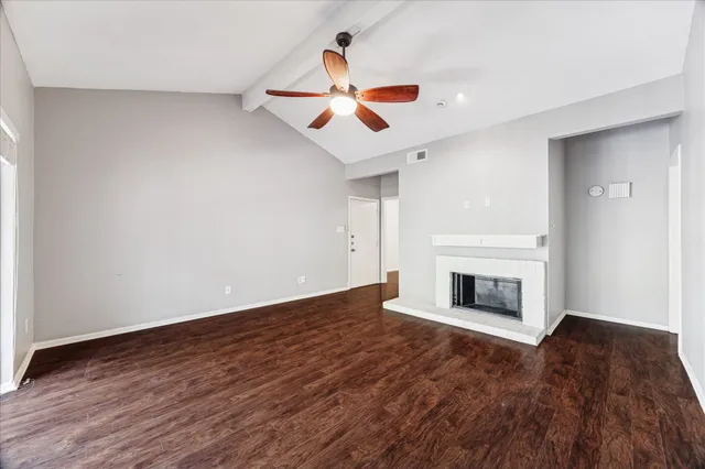 a view of empty room with wooden floor fireplace and window