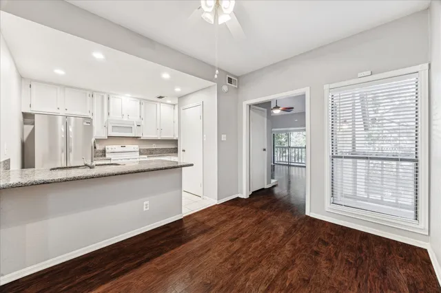 a kitchen with stainless steel appliances granite countertop a refrigerator a sink and a stove