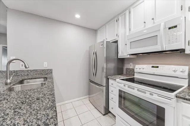 a kitchen with white cabinets and stainless steel appliances