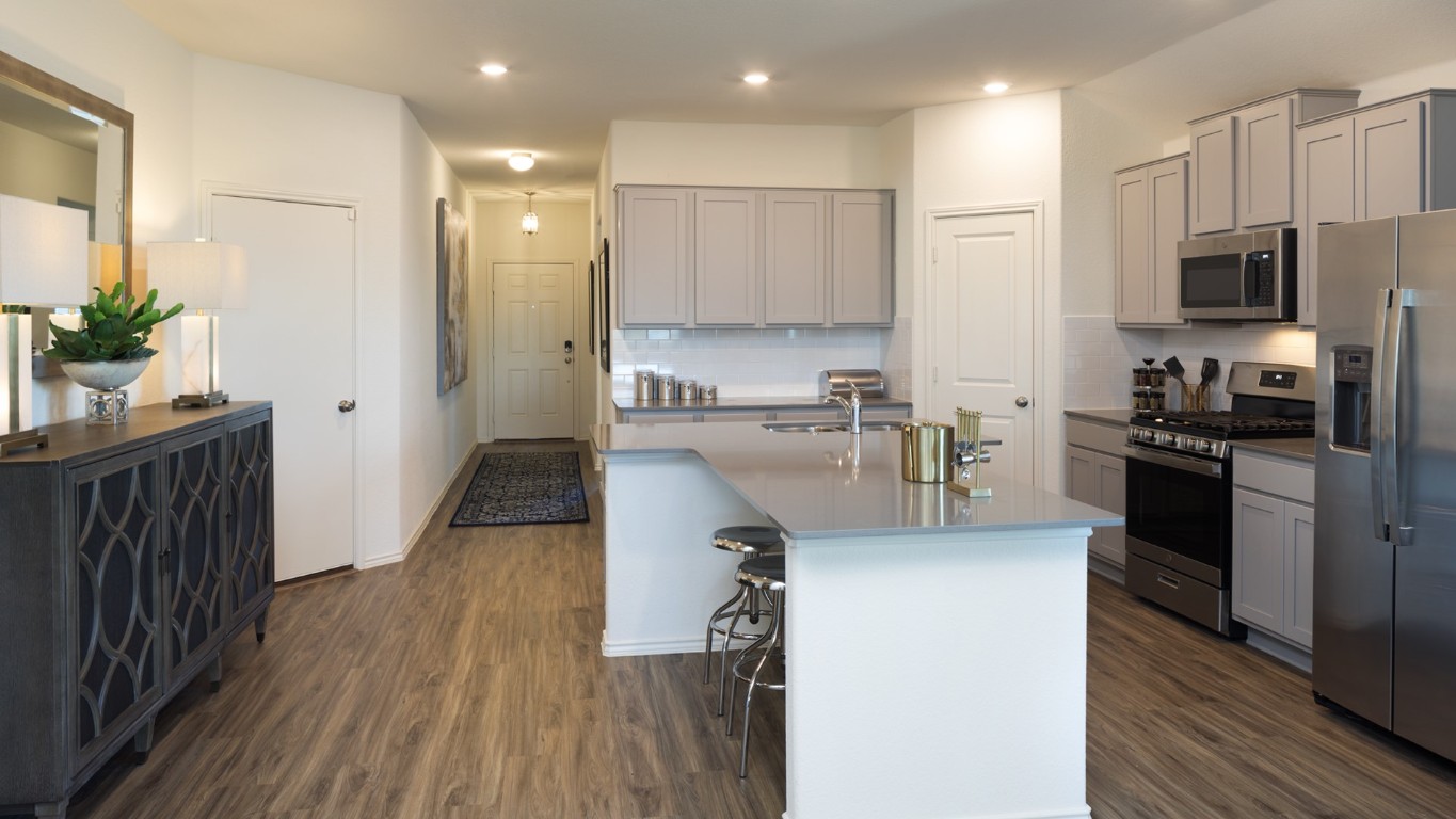1712 Boggy Crk Rnch Road Georgetown, TX 78628 - Photo 12 of 19 a kitchen with stainless steel appliances granite countertop a refrigerator a stove top oven a sink dishwasher and wooden floor