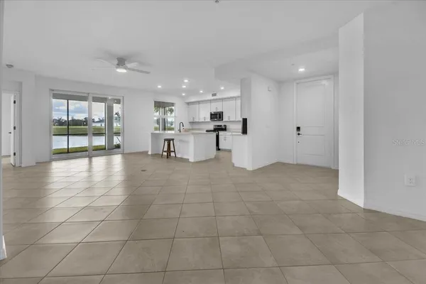 a kitchen with stainless steel appliances granite countertop a refrigerator a sink a stove top oven and a center island