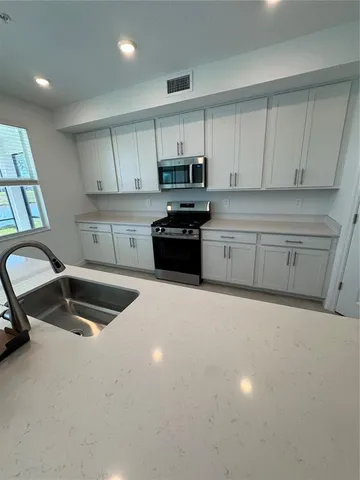 a kitchen with granite countertop a sink and a stove top oven