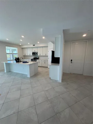 a large white kitchen with stainless steel appliances granite countertop a large counter top and oven