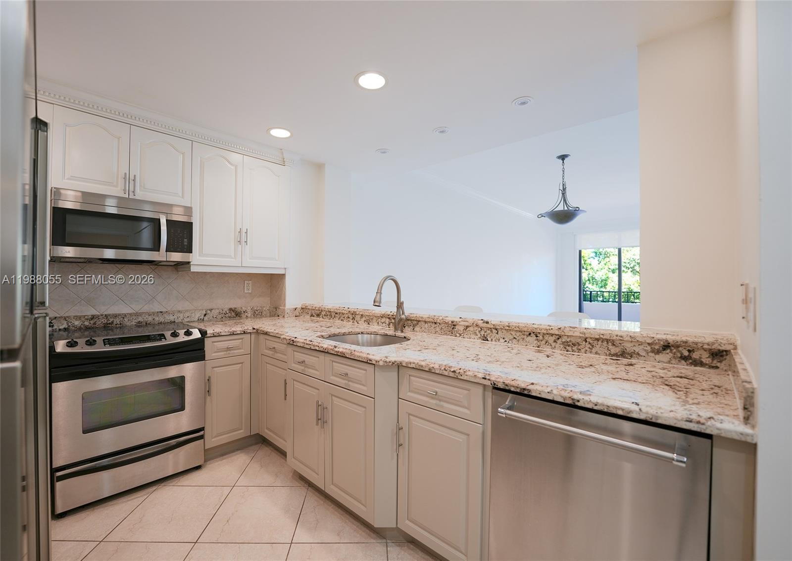 151 Crandon Boulevard, Unit 320 Key Biscayne, FL 33149 - Photo 4 of 10 a kitchen with stainless steel appliances granite countertop a sink and stove top oven