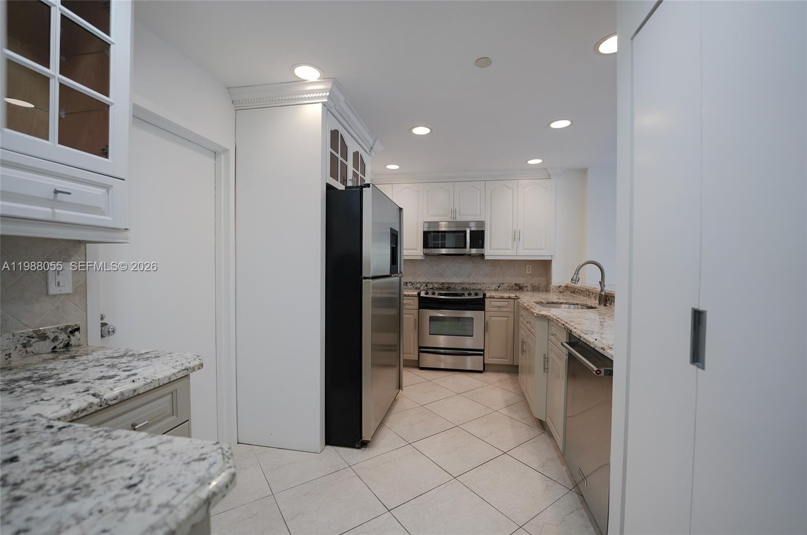 151 Crandon Boulevard, Unit 320 Key Biscayne, FL 33149 - Photo 5 of 10 a kitchen with stainless steel appliances granite countertop a refrigerator and a stove top oven