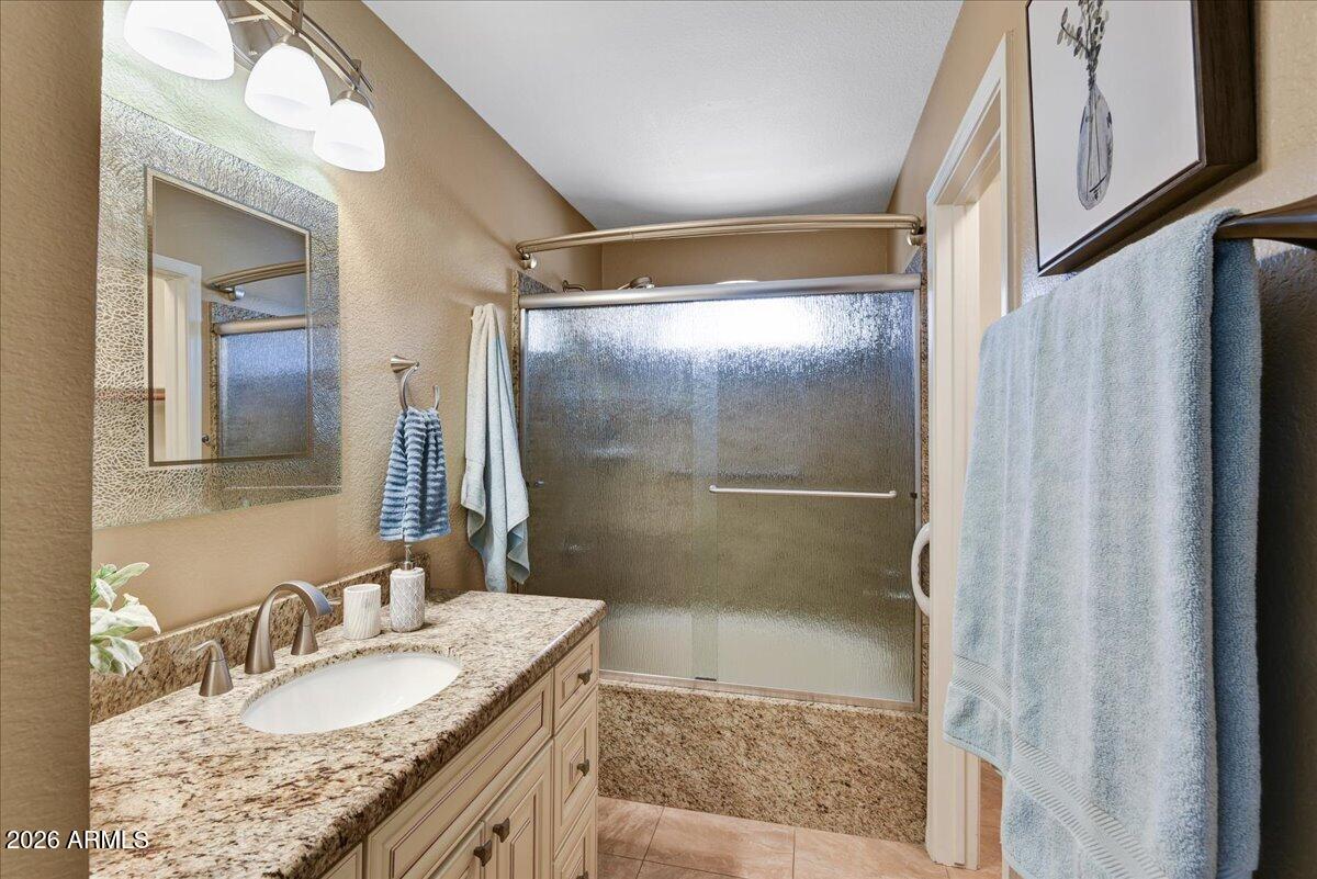 9136 West Rimrock Drive Peoria, AZ 85382 - Photo 19 of 25 a bathroom with a granite countertop shower sink and mirror
