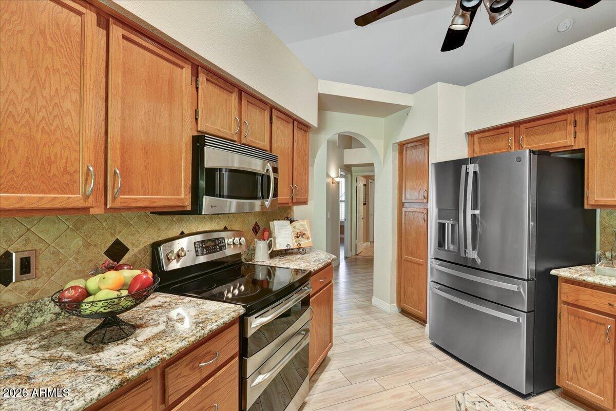 9136 West Rimrock Drive Peoria, AZ 85382 - Photo 7 of 25 a kitchen with stainless steel appliances granite countertop a refrigerator stove and sink