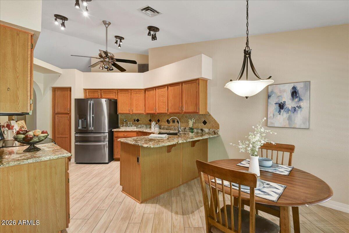 9136 West Rimrock Drive Peoria, AZ 85382 - Photo 9 of 25 a kitchen with a table chairs refrigerator and microwave