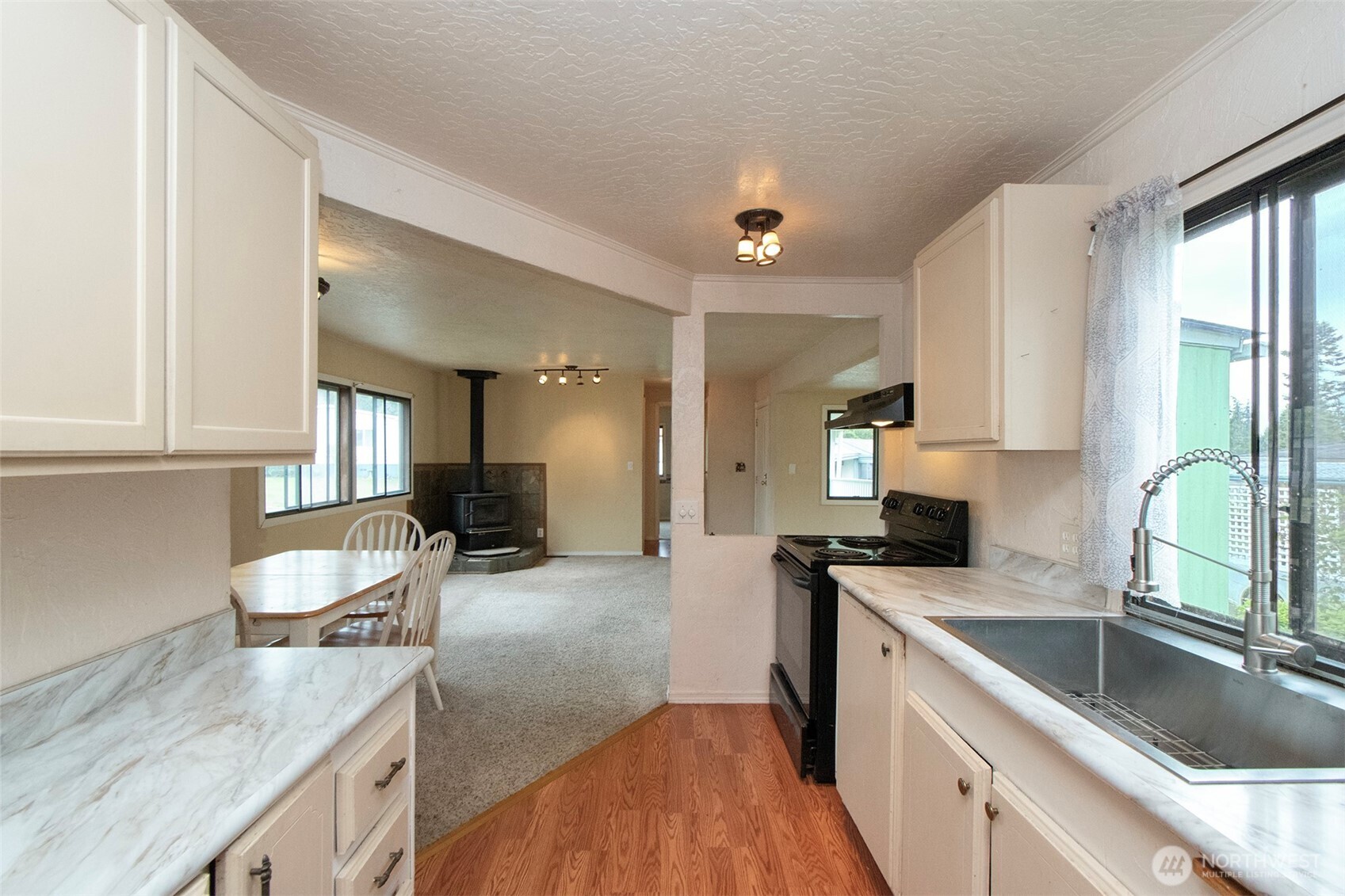 90 Baywood Village Road, Unit 34 Sequim, WA 98382 - Photo 17 of 40 a kitchen with a stove a sink and a refrigerator