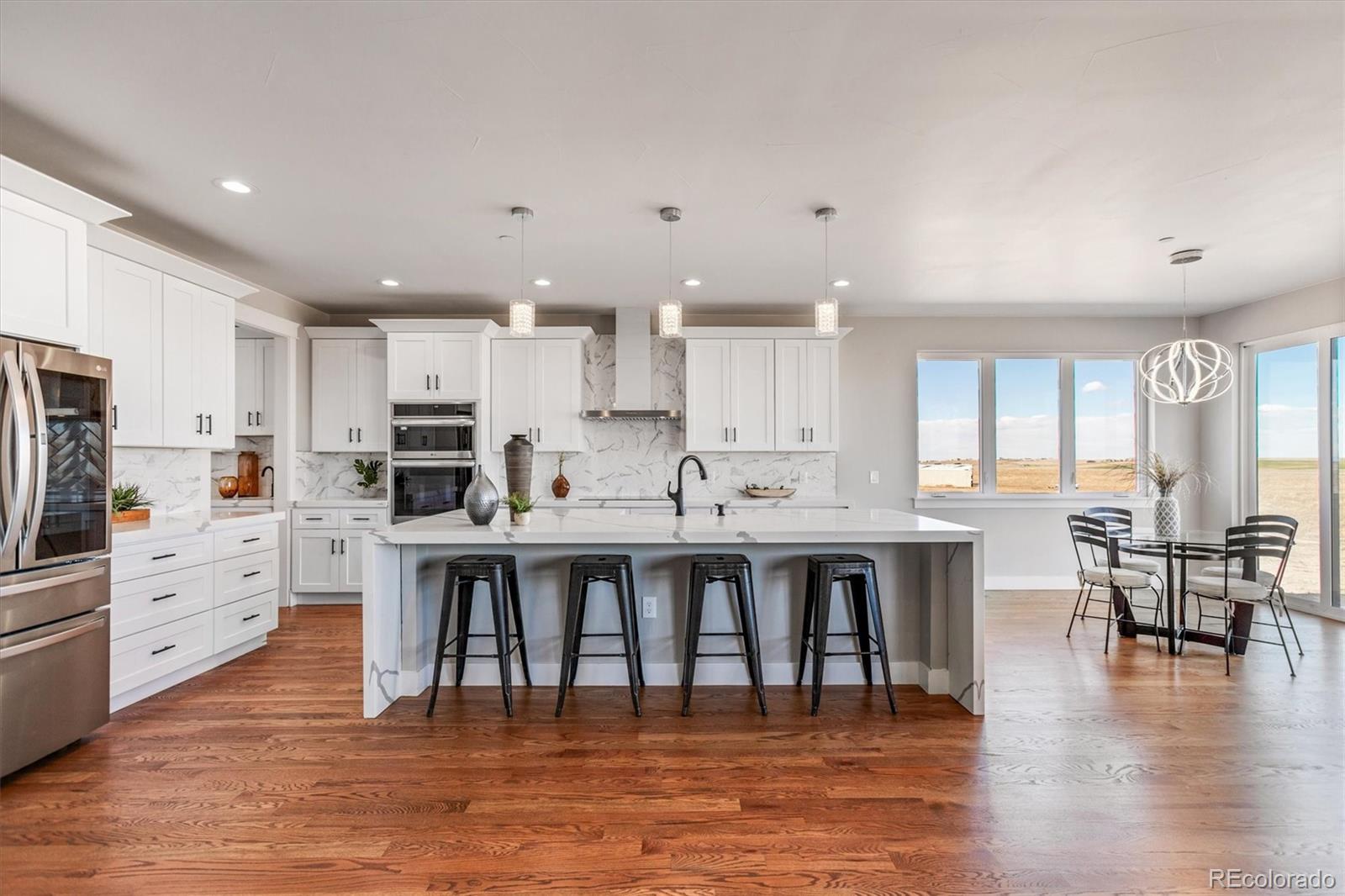 13350 Imboden Road Hudson, CO 80642 - Photo 7 of 50 a large white kitchen with lots of counter space and furniture