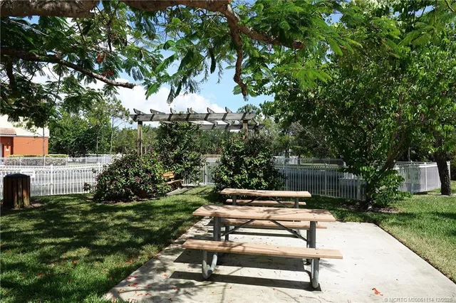 a view of a patio with table and chairs and a barbeque