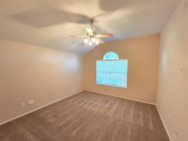 an empty room with a window and a fan