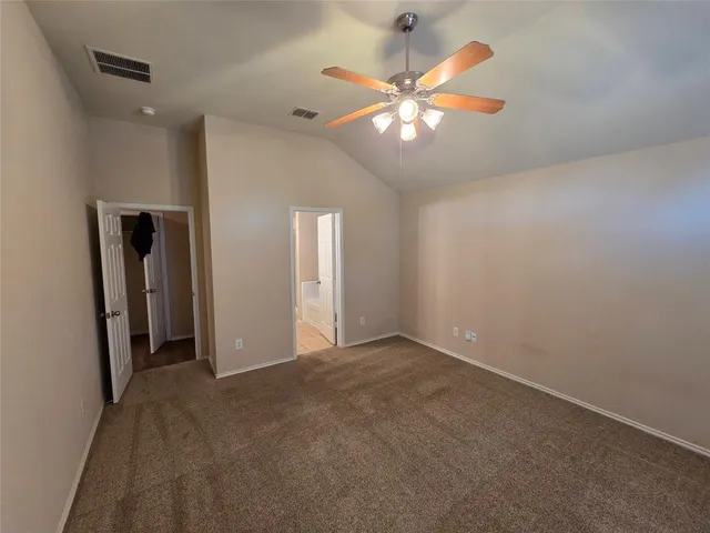 en empty room with windows and ceiling fan