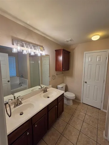 an empty room with chandelier fan and windows