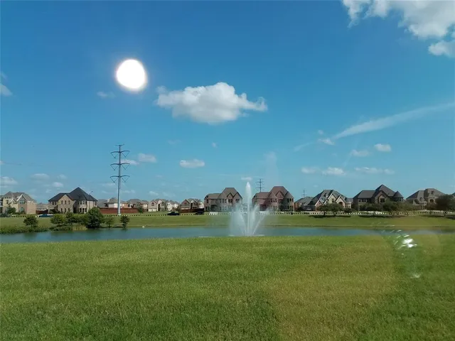 a view of a lake with a yard and a large tree