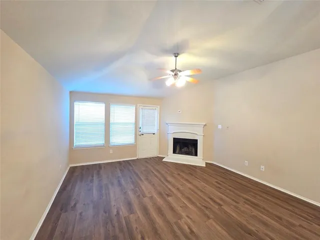 a view of empty room with wooden floor and fireplace