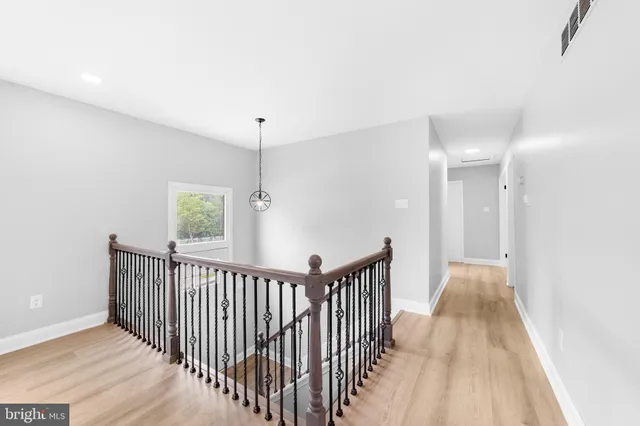 a view of a hallway with wooden floor and windows