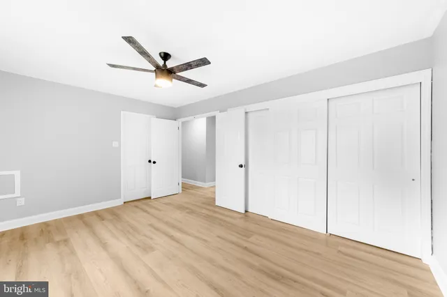 a view of a room with wooden floor and a ceiling fan