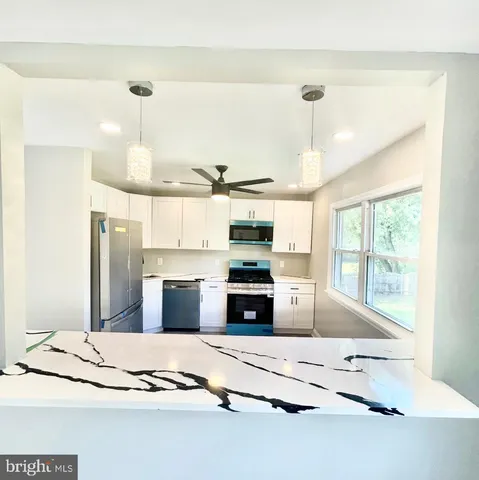 a kitchen with stainless steel appliances kitchen island granite countertop a sink and cabinets