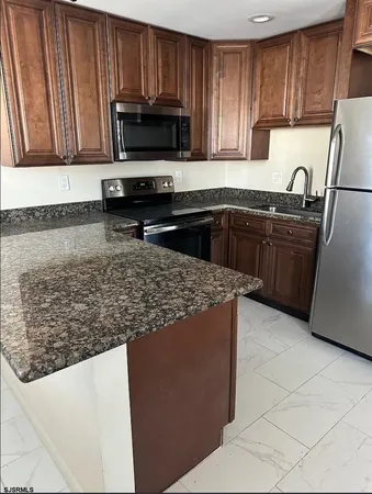 a kitchen with stainless steel appliances granite countertop a stove microwave and refrigerator