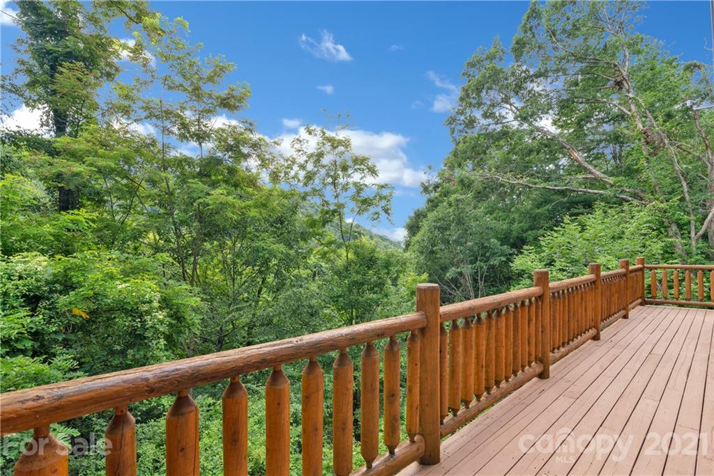 210 Angel Falls Road Clyde, NC 28721 - Photo 14 of 40 a balcony with wooden floor and trees in the back