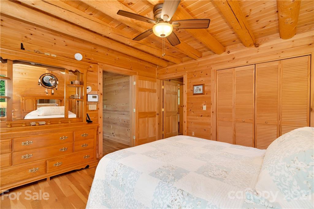 210 Angel Falls Road Clyde, NC 28721 - Photo 22 of 40 a bedroom with a bed and a chandelier