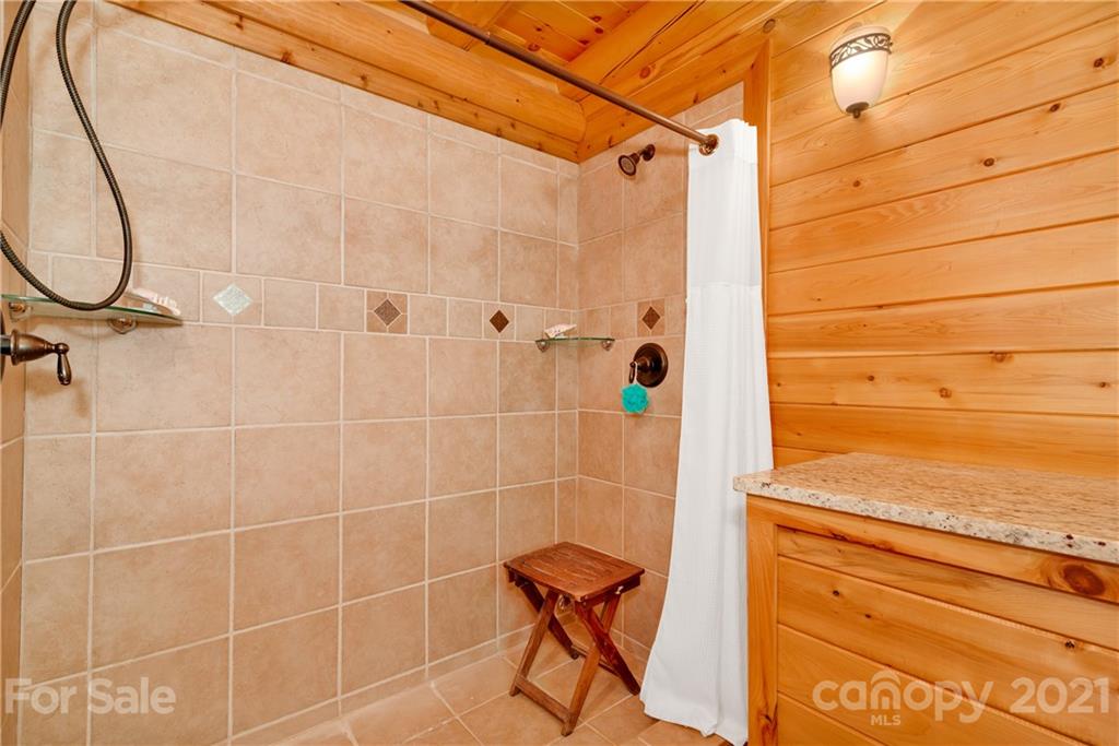 210 Angel Falls Road Clyde, NC 28721 - Photo 24 of 40 a bathroom with a shower and a mirror