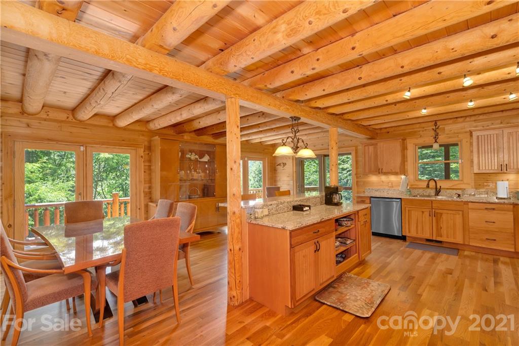 210 Angel Falls Road Clyde, NC 28721 - Photo 8 of 40 a large kitchen with stainless steel appliances wooden floors and large windows
