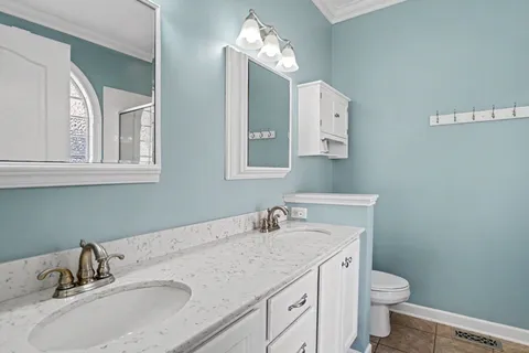 a bathroom with a granite countertop toilet a sink and mirror