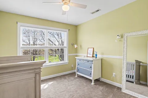 a view of a bedroom with a window and a ceiling fan