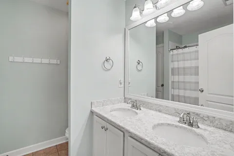 a bathroom with a granite countertop sink a large mirror and a shower