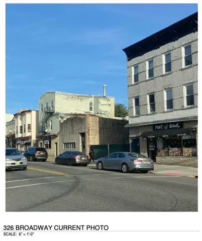 a front view of a building with cars parked