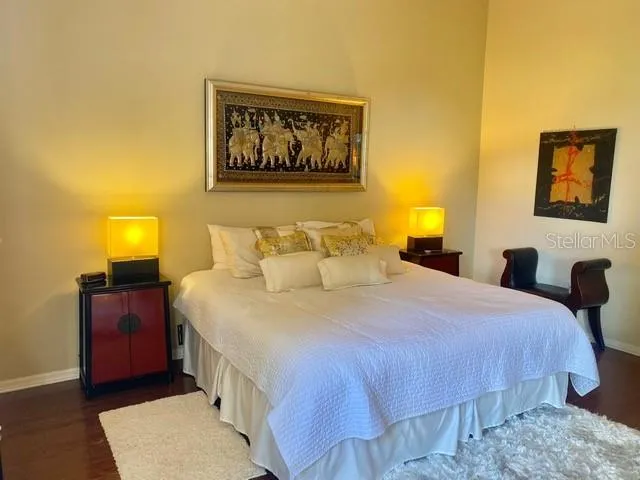 a bedroom with bed and paintings on the wall