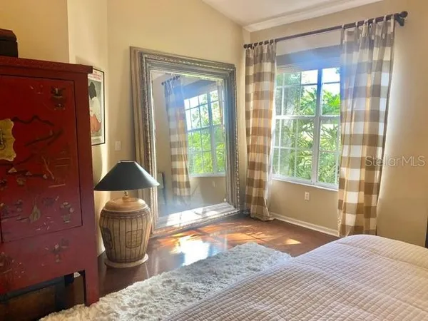 a bedroom with a bed and wooden floor