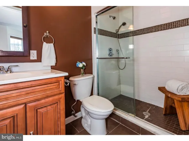 a bathroom with a sink a toilet a mirror and shower