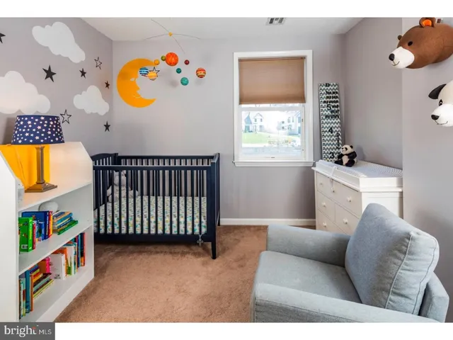 a living room with baby crib and a window