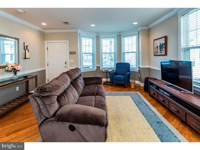 a living room with furniture a flat screen tv and a window