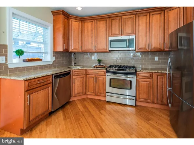 a kitchen with stainless steel appliances granite countertop a stove a sink dishwasher and a microwave