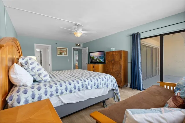 a bedroom with a bed and dresser with wooden floor