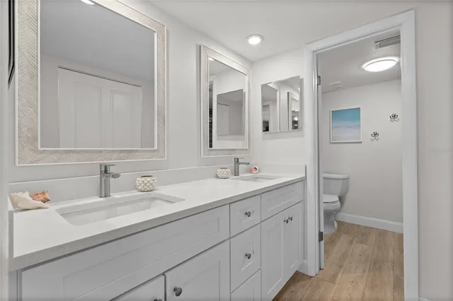 a bathroom with a sink a toilet and a mirror