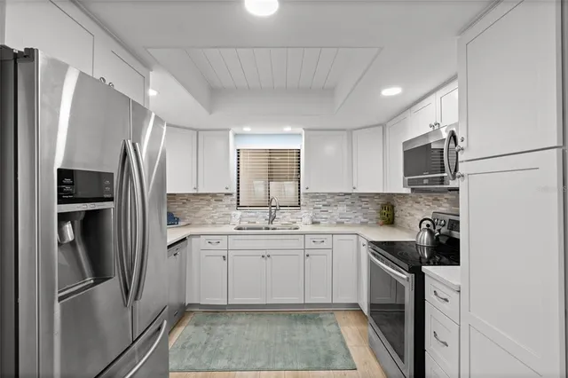 a kitchen with a sink stainless steel appliances and cabinets