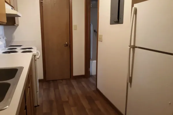 a kitchen with stainless steel appliances granite countertop a sink a refrigerator a stove and a refrigerator with wooden cabinets