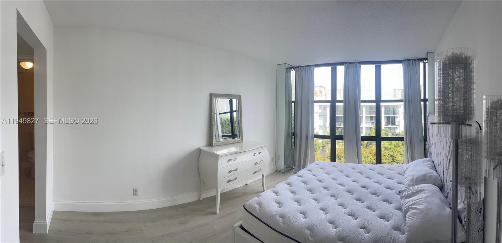 17021 North Bay Road, Unit 603 Sunny Isles Beach, FL 33160 - Photo 6 of 9 a bedroom with a bed and a window