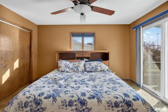 a bedroom with a bed and a large window