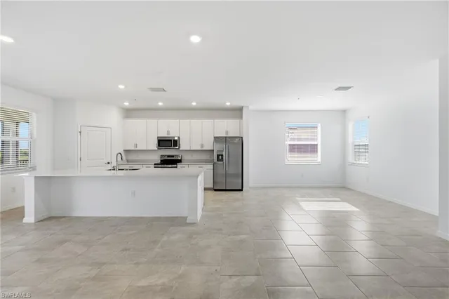 a view of kitchen with stainless steel appliances refrigerator sink and cabinets