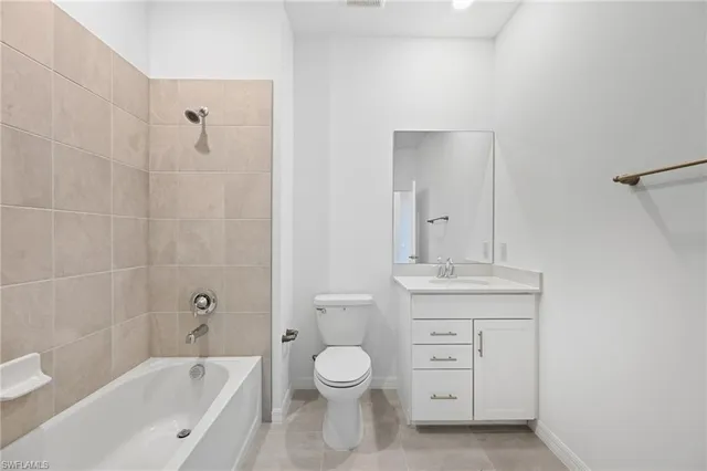a bathroom with a granite countertop toilet a sink and a bathtub