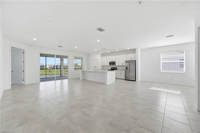 a view of kitchen with refrigerator sink and white cabinets